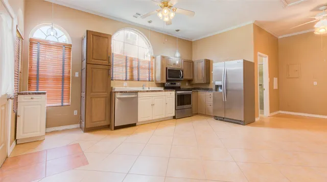 a kitchen with stainless steel appliances granite countertop a stove top oven a refrigerator a sink and dishwasher