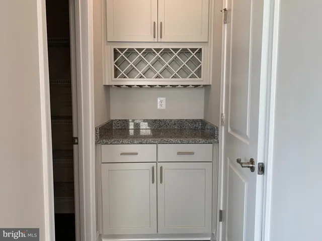 a bathroom with a granite countertop sink and washing machine