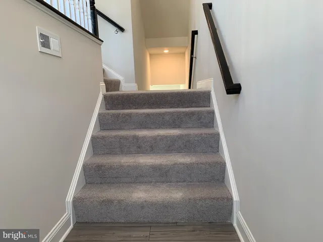 a view of staircase with white walls and a window