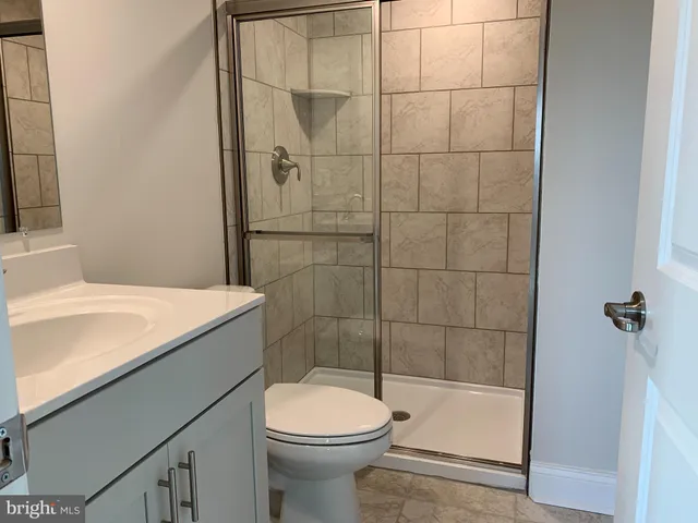 a bathroom with a granite countertop bathtub shower and toilet