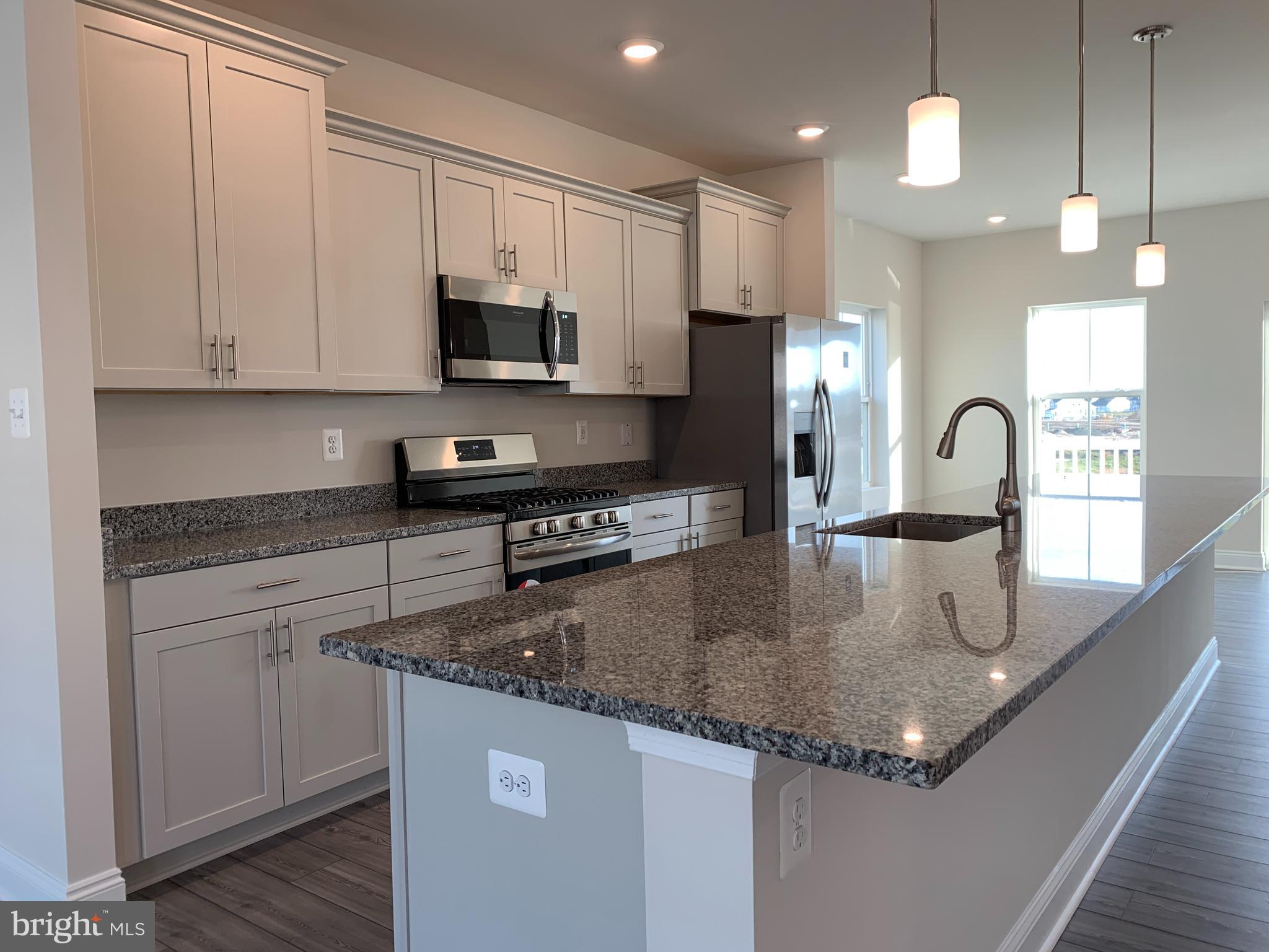 35318 Wright Way Millsboro, DE 19966 - Photo 6 of 28 a kitchen with granite countertop a sink a counter top space cabinets and stainless steel appliances