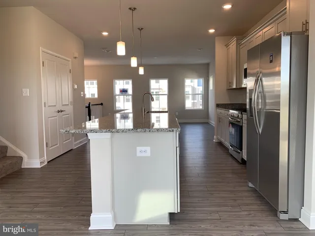 a view of a hallway the wooden floor and a living room