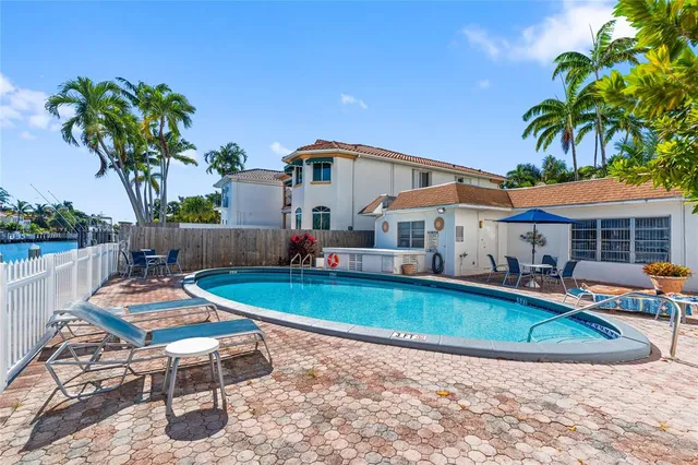 a view of a house with swimming pool and sitting area