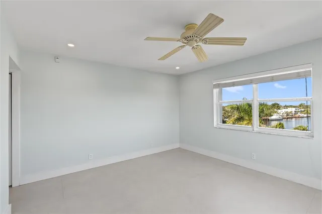 an empty room with windows and fan