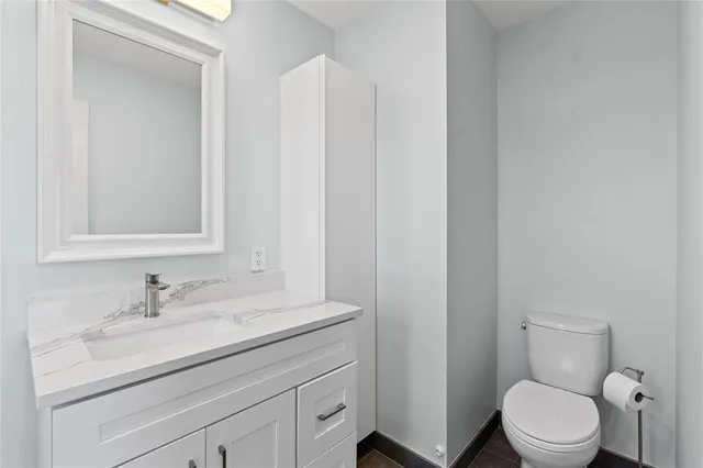 a bathroom with a toilet a sink and mirror