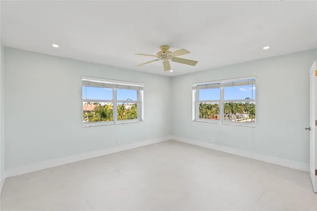 en empty room with windows and ceiling fan