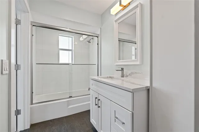 a bathroom with a granite countertop sink mirror and a bathtub