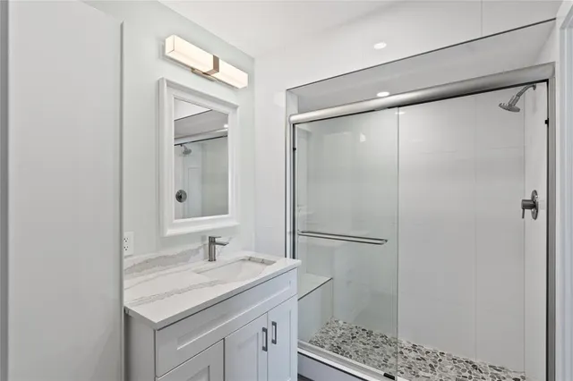 a bathroom with a granite countertop sink toilet and shower