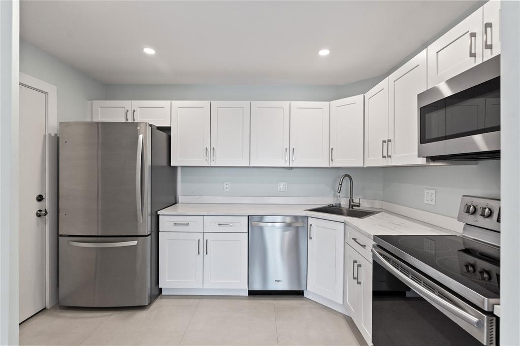 1770 East Las Olas Boulevard, Unit 505 Fort Lauderdale, FL 33301 - Photo 10 of 33 a kitchen with stainless steel appliances granite countertop a refrigerator a stove a sink and white cabinets