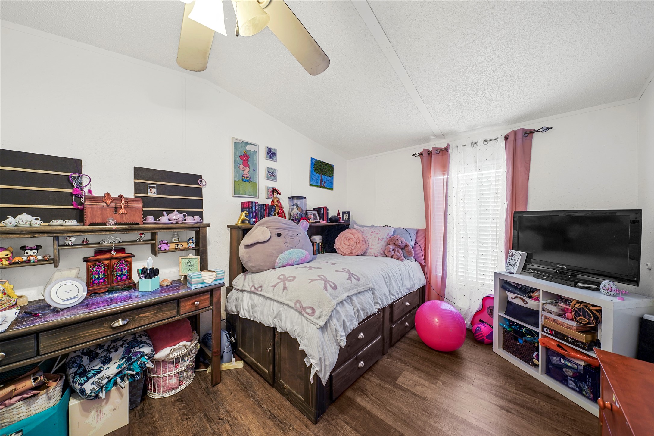 19645 Nordt Road Damon, TX 77430 - Photo 32 of 50 a bedroom with a bed a flat screen tv and a chandelier