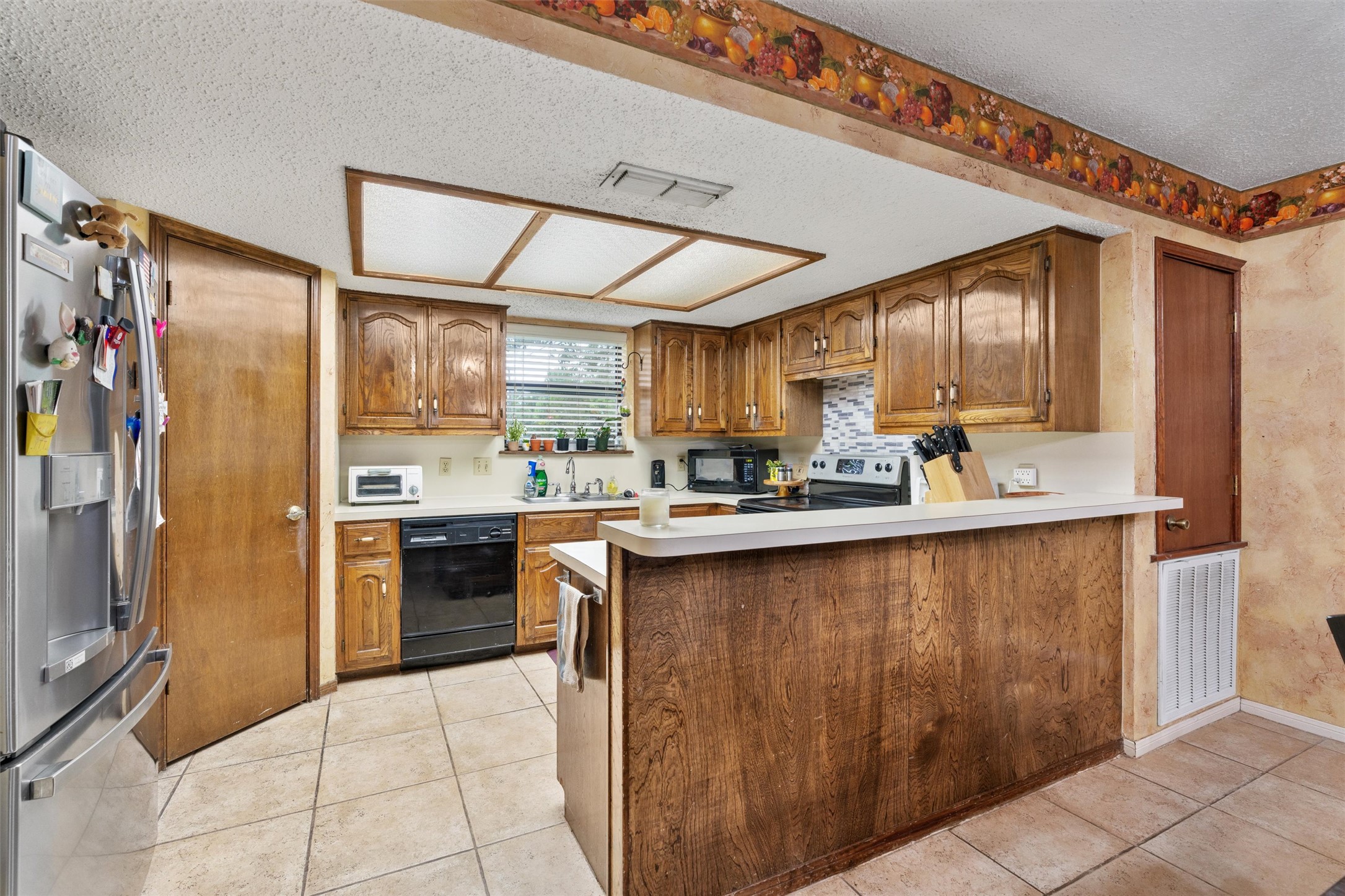 401 Drake Lane Taylor, TX 76574 - Photo 9 of 31 Kitchen featuring wood cabinetry, white countertops, tile flooring, and a recessed ceiling light fixture