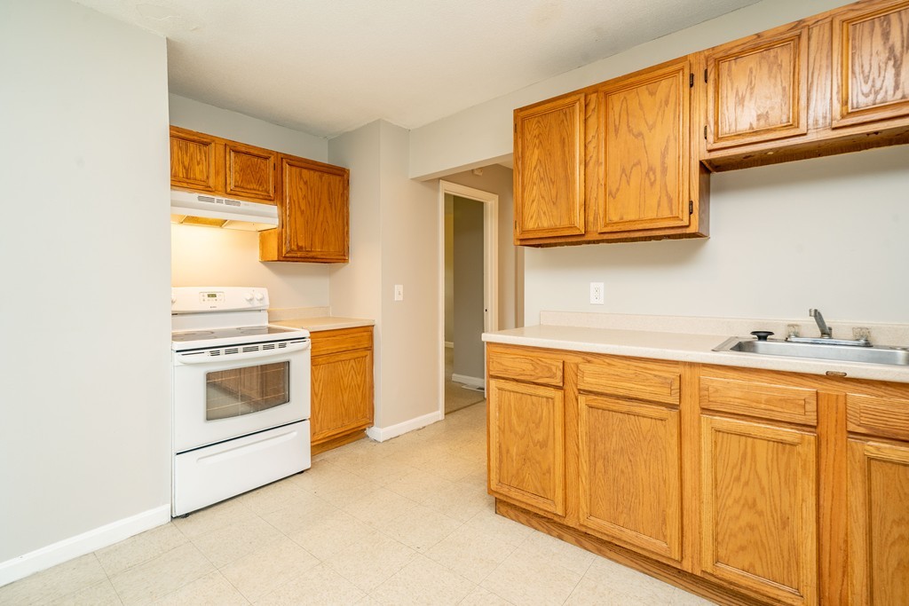 16 Collins Street Springfield, MA 01109 - Photo 4 of 17 a kitchen with granite countertop cabinets stainless steel appliances and a sink