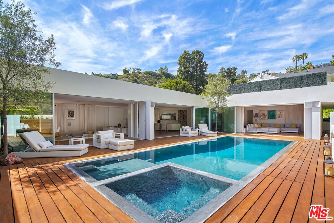 a view of a house with swimming pool and sitting space