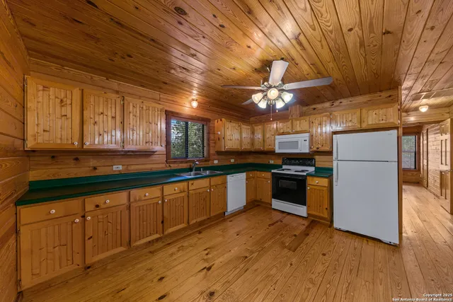 a kitchen with granite countertop a sink cabinets and stainless steel appliances
