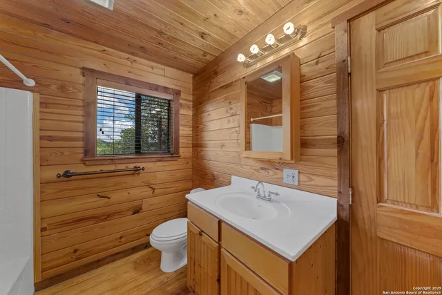 a bathroom with a sink a toilet and mirror