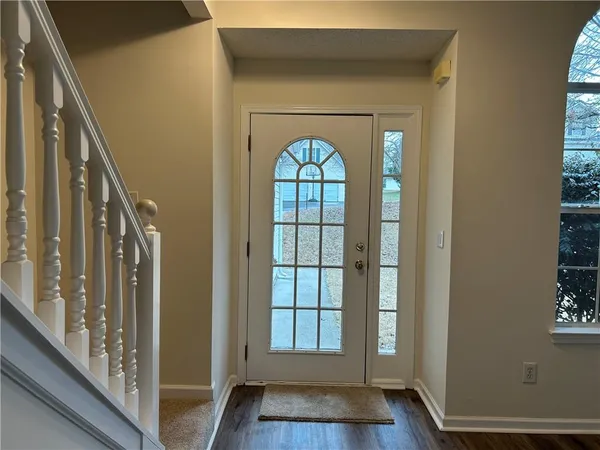 a view of empty room with wooden floor and fireplace