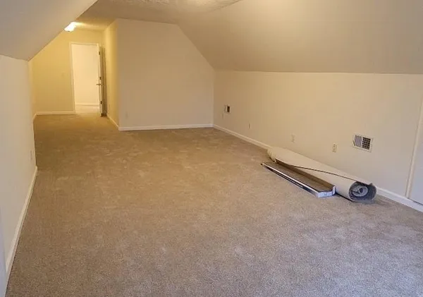 a view of an empty room with a fireplace and a fan