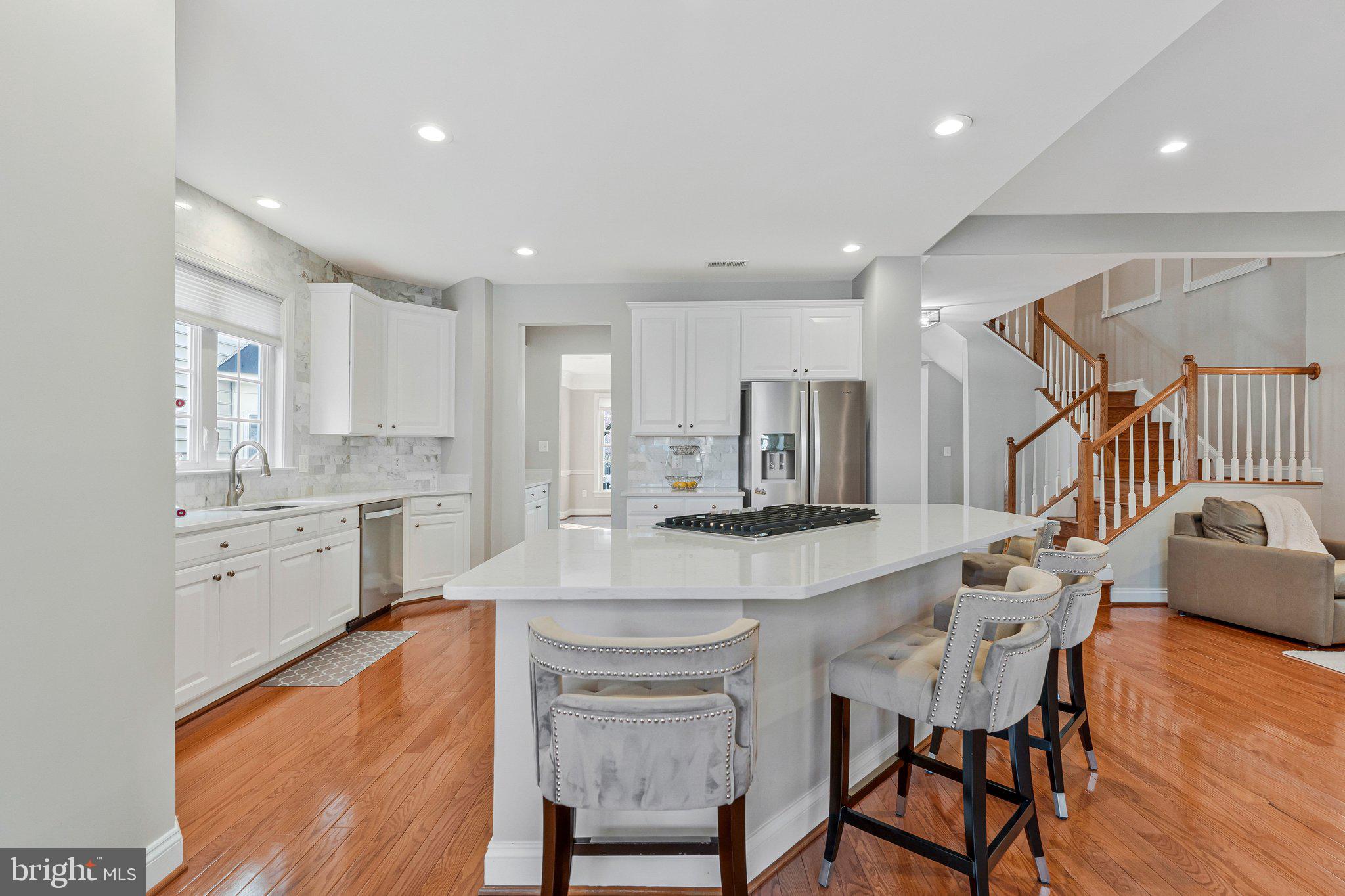 9183 Topaz Street Fairfax, VA 22031 - Photo 15 of 67 a kitchen with stainless steel appliances kitchen island granite countertop a table chairs sink and cabinets
