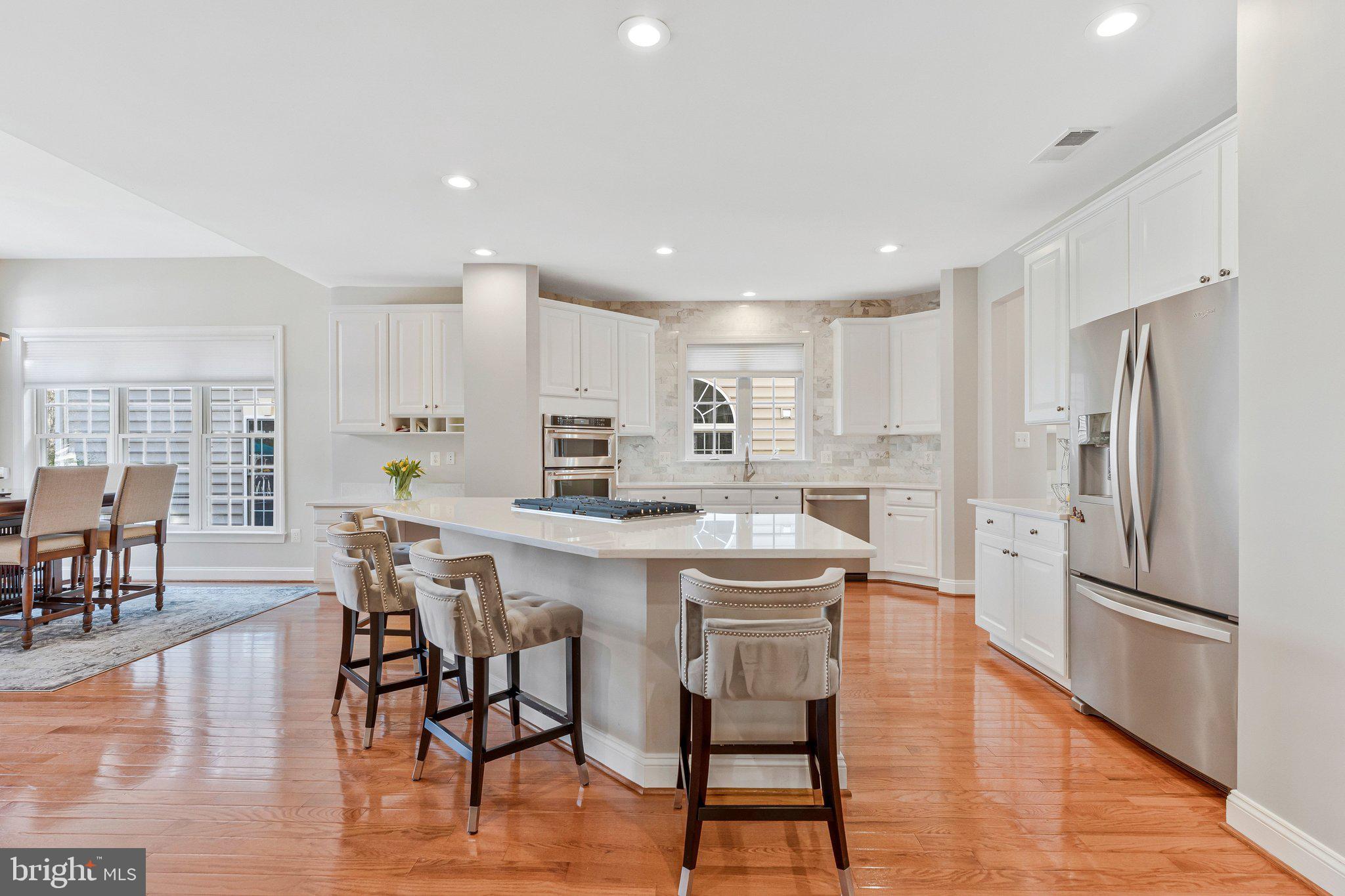 9183 Topaz Street Fairfax, VA 22031 - Photo 17 of 67 a kitchen with stainless steel appliances a dining table chairs stove refrigerator and cabinets