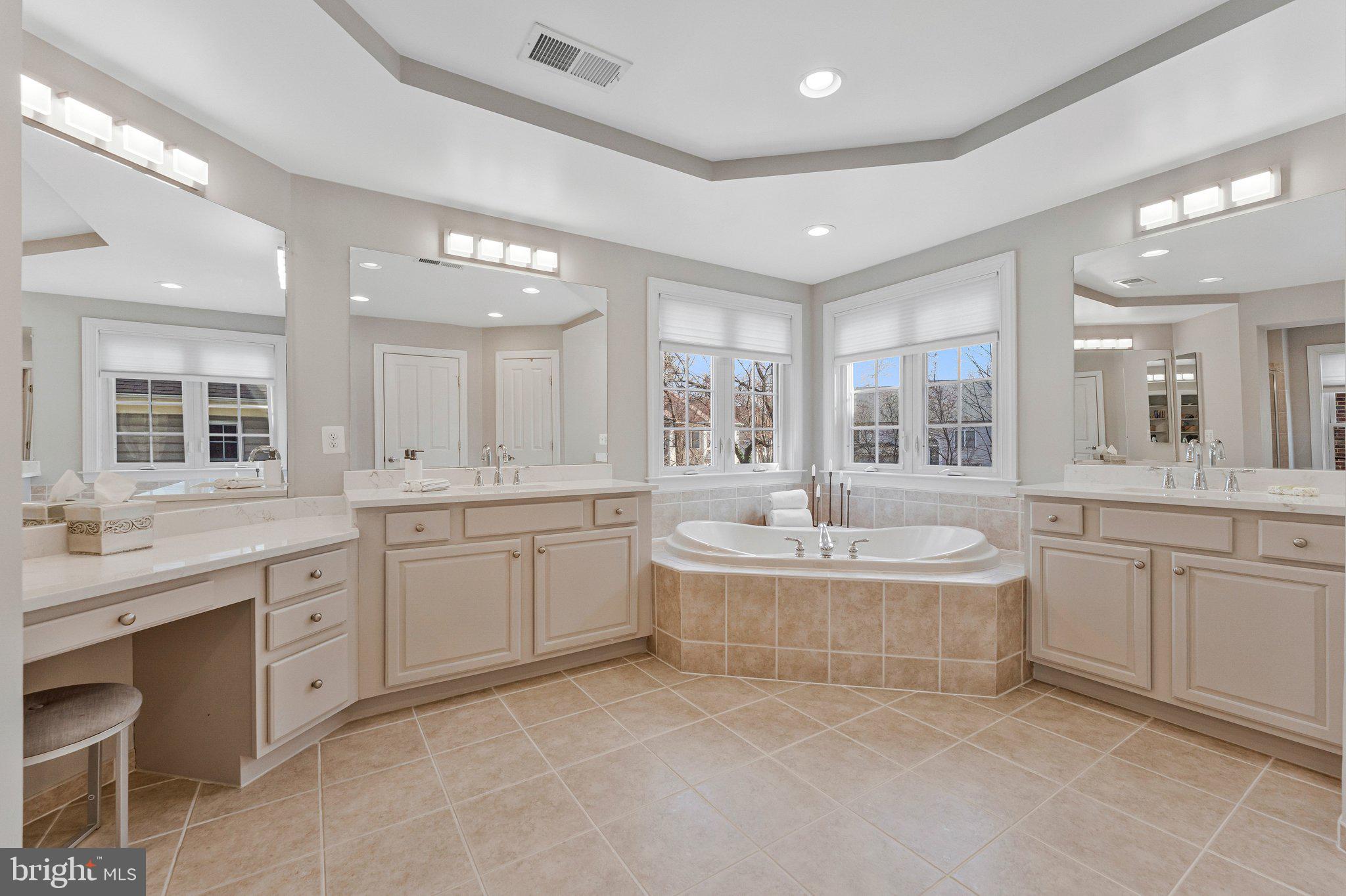 9183 Topaz Street Fairfax, VA 22031 - Photo 35 of 67 a large bathroom with a double vanity sink a large mirror and a bathtub