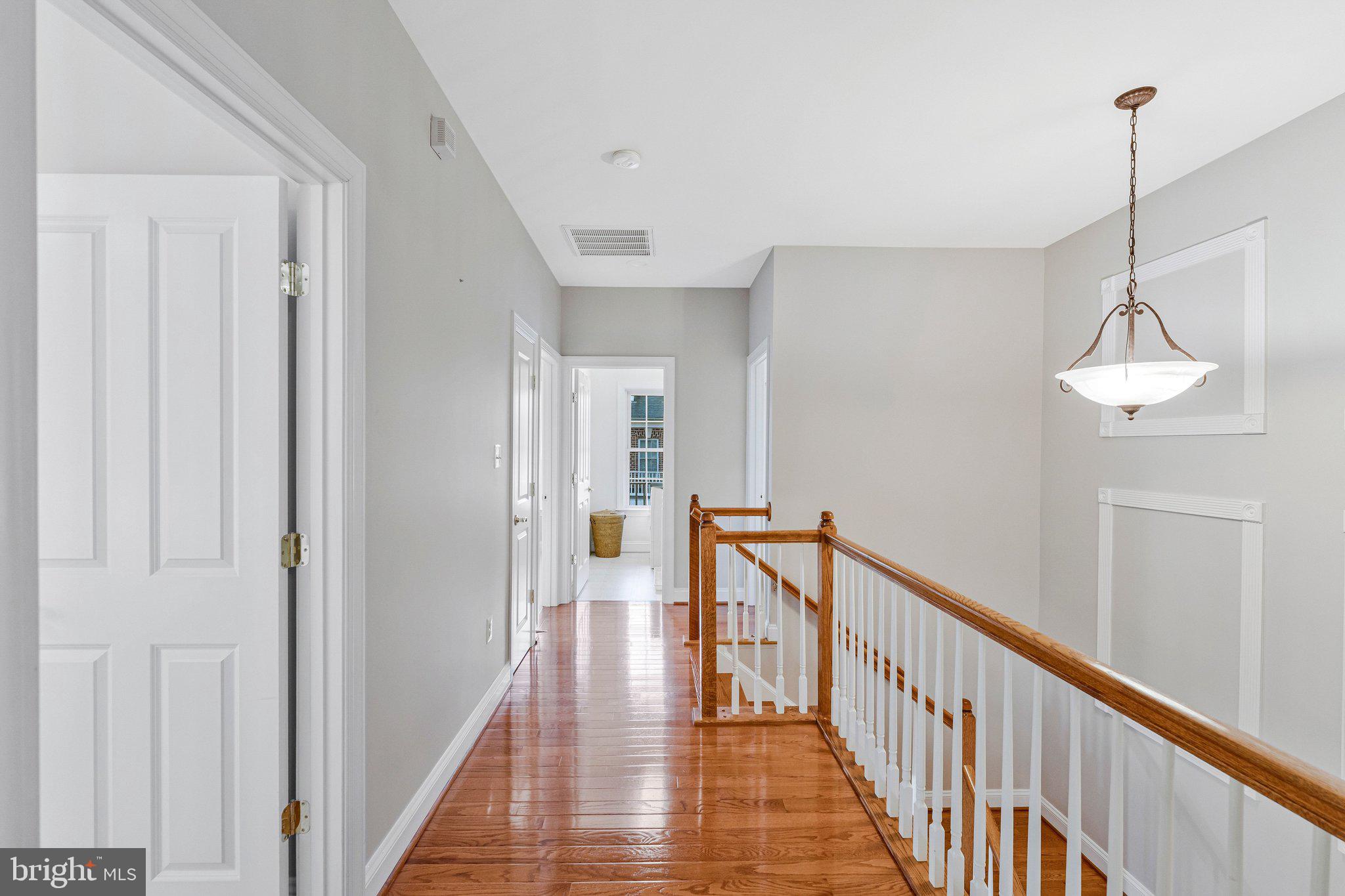 9183 Topaz Street Fairfax, VA 22031 - Photo 38 of 67 a view of a hallway with wooden floor and staircase