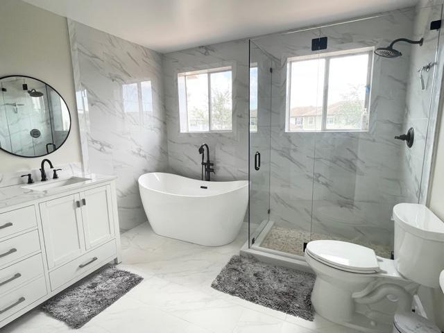 6763 Via Regina Boca Raton, FL 33433 - Photo 12 of 39 a bathroom with a sink toilet a mirror and shower