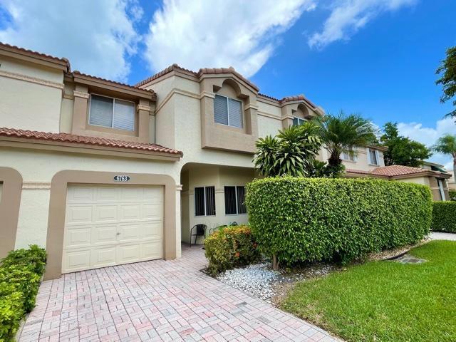 6763 Via Regina Boca Raton, FL 33433 - Photo 2 of 39 a front view of a house with a garden