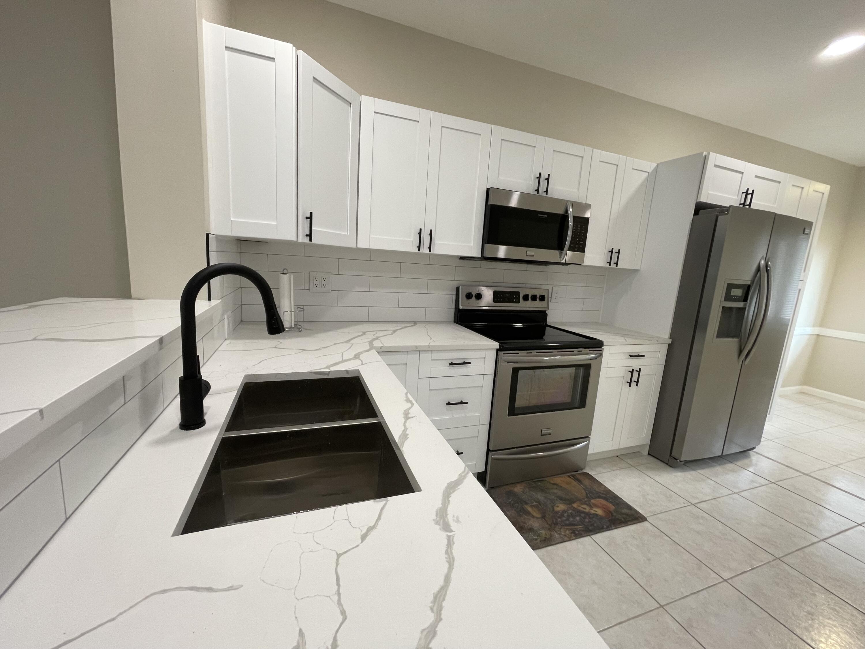 6763 Via Regina Boca Raton, FL 33433 - Photo 3 of 39 a kitchen with a sink a stove and refrigerator