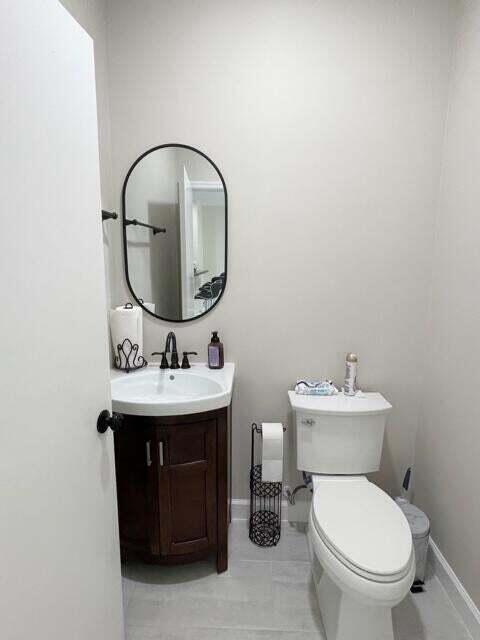 6763 Via Regina Boca Raton, FL 33433 - Photo 32 of 39 a bathroom with a toilet a sink and a mirror