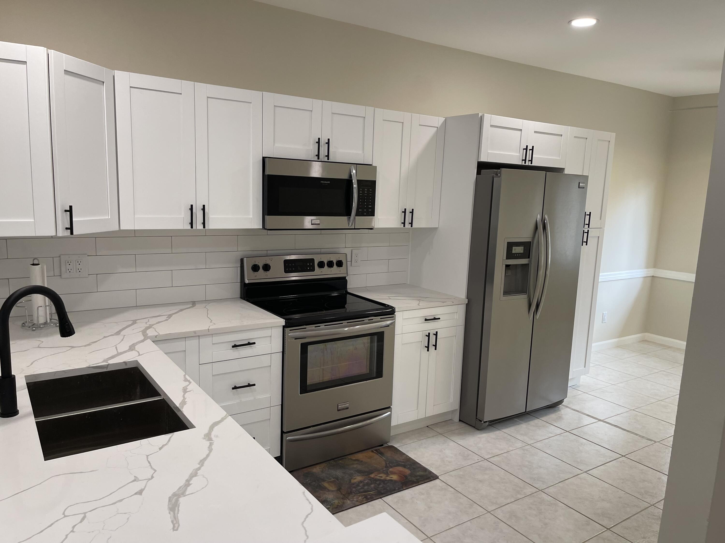6763 Via Regina Boca Raton, FL 33433 - Photo 4 of 39 a kitchen with stainless steel appliances a refrigerator sink and microwave