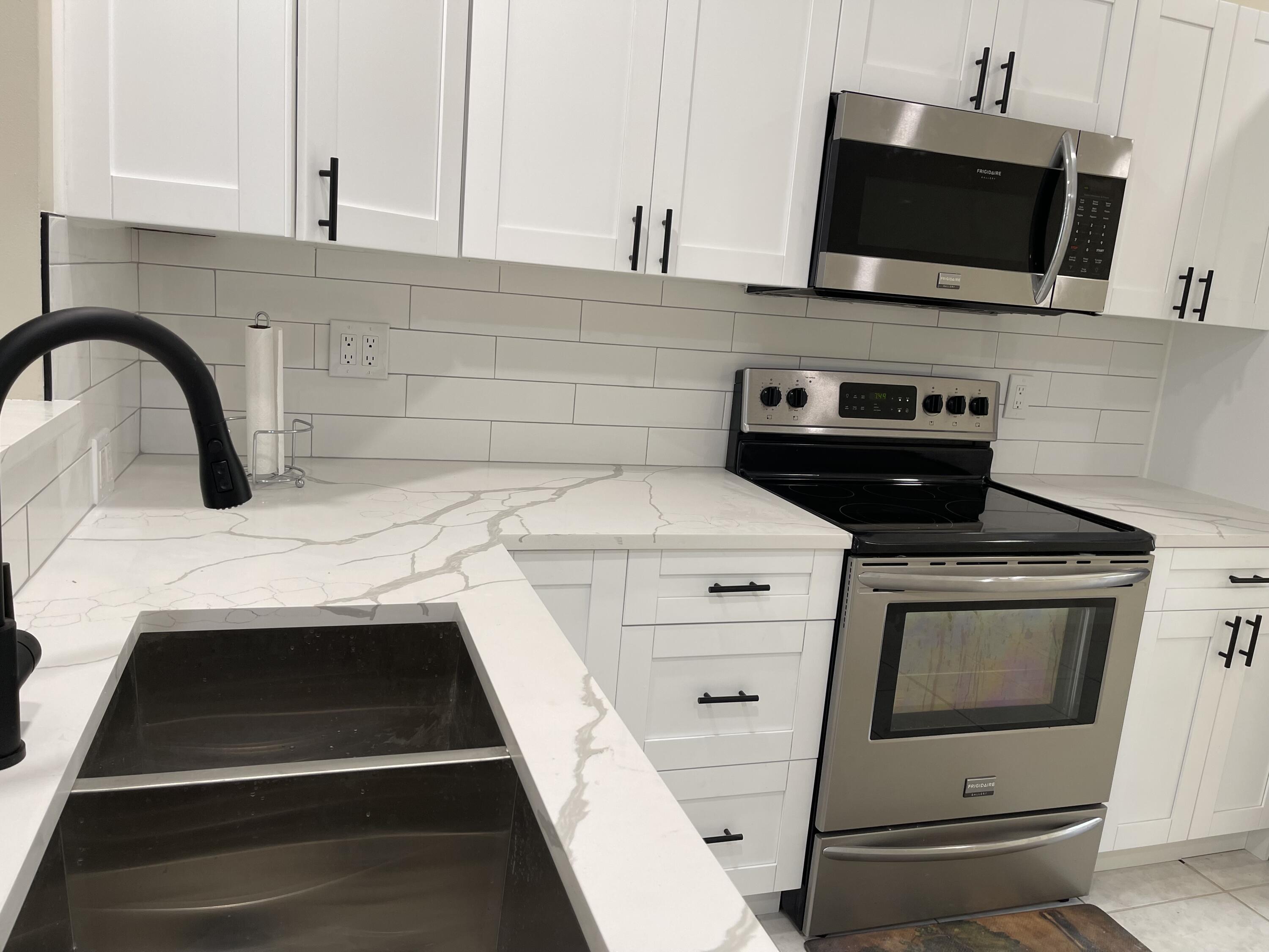 6763 Via Regina Boca Raton, FL 33433 - Photo 6 of 39 a kitchen with a stove and a microwave