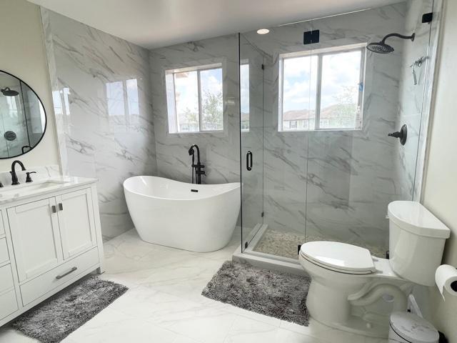 6763 Via Regina Boca Raton, FL 33433 - Photo 8 of 39 a bathroom with a white toilet sitting next to a bathroom sink and a shower