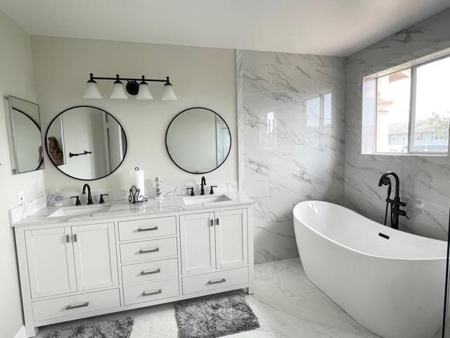 6763 Via Regina Boca Raton, FL 33433 - Photo 9 of 39 a bathroom with a double vanity sink a mirror and bathtub