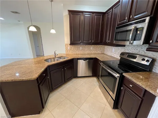 a kitchen with stainless steel appliances granite countertop a sink stove and microwave