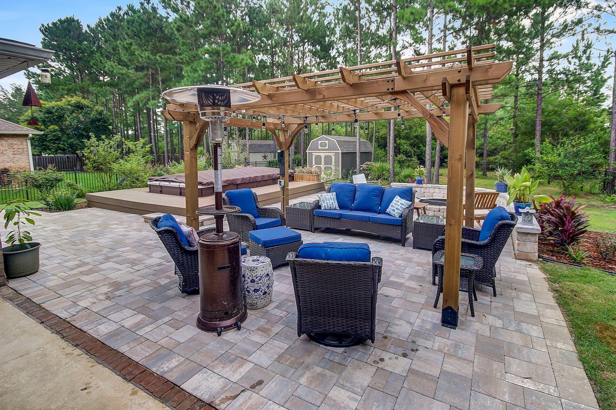 28 Haven Way Freeport, FL 32439 - Photo 33 of 50 a view of a patio with table and chairs potted plants with large tree