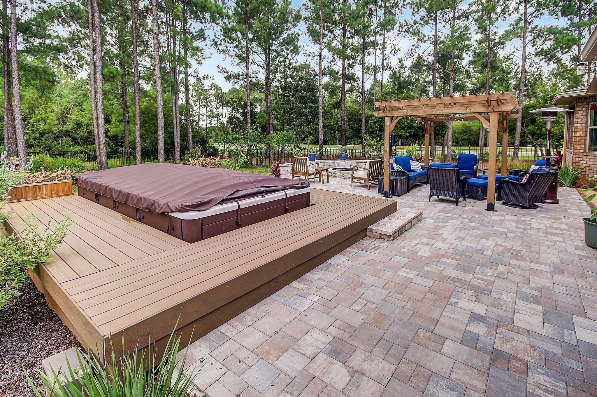 28 Haven Way Freeport, FL 32439 - Photo 34 of 50 a view of a patio with couches table and chairs under an umbrella with large trees