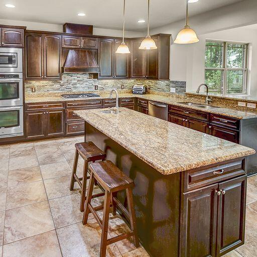 28 Haven Way Freeport, FL 32439 - Photo 10 of 50 a kitchen with stainless steel appliances granite countertop wooden cabinets a stove a sink and a refrigerator