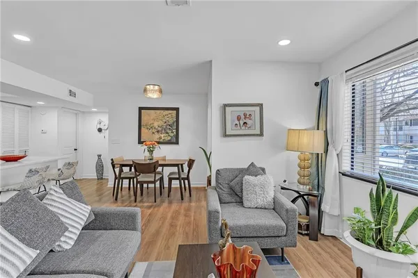a living room with furniture wooden floor and a large window