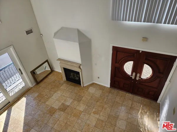 a view of an empty room with wooden floor and a fire place