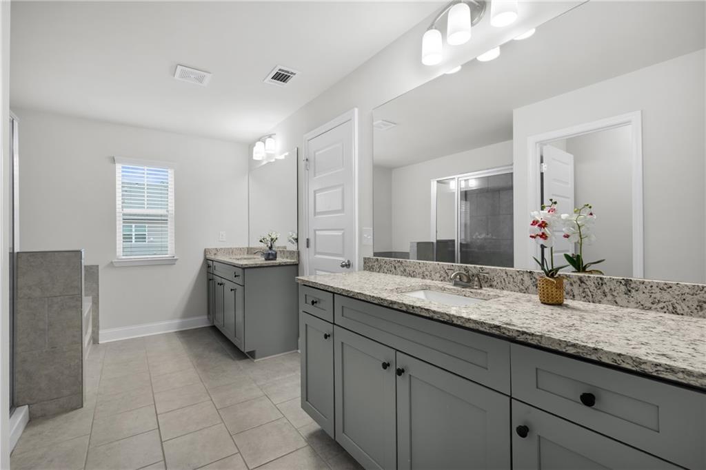 6710 Cedar Glen Road Atlanta, GA 30360 - Photo 22 of 35 a bathroom with a granite countertop sink a large mirror and a bathtub
