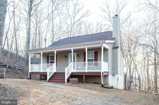 a view of a house with a yard and large tree