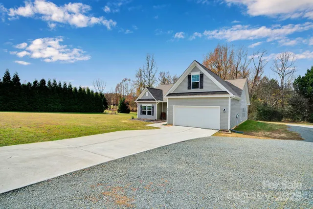 a house with green field in front of it