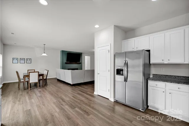 a living room with stainless steel appliances furniture and a flat screen tv