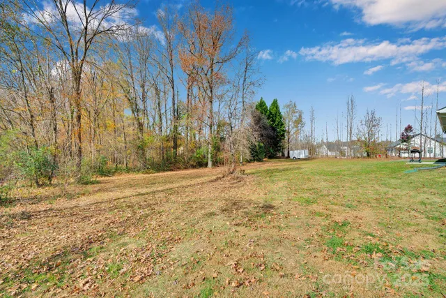 a large house with a big yard and large trees