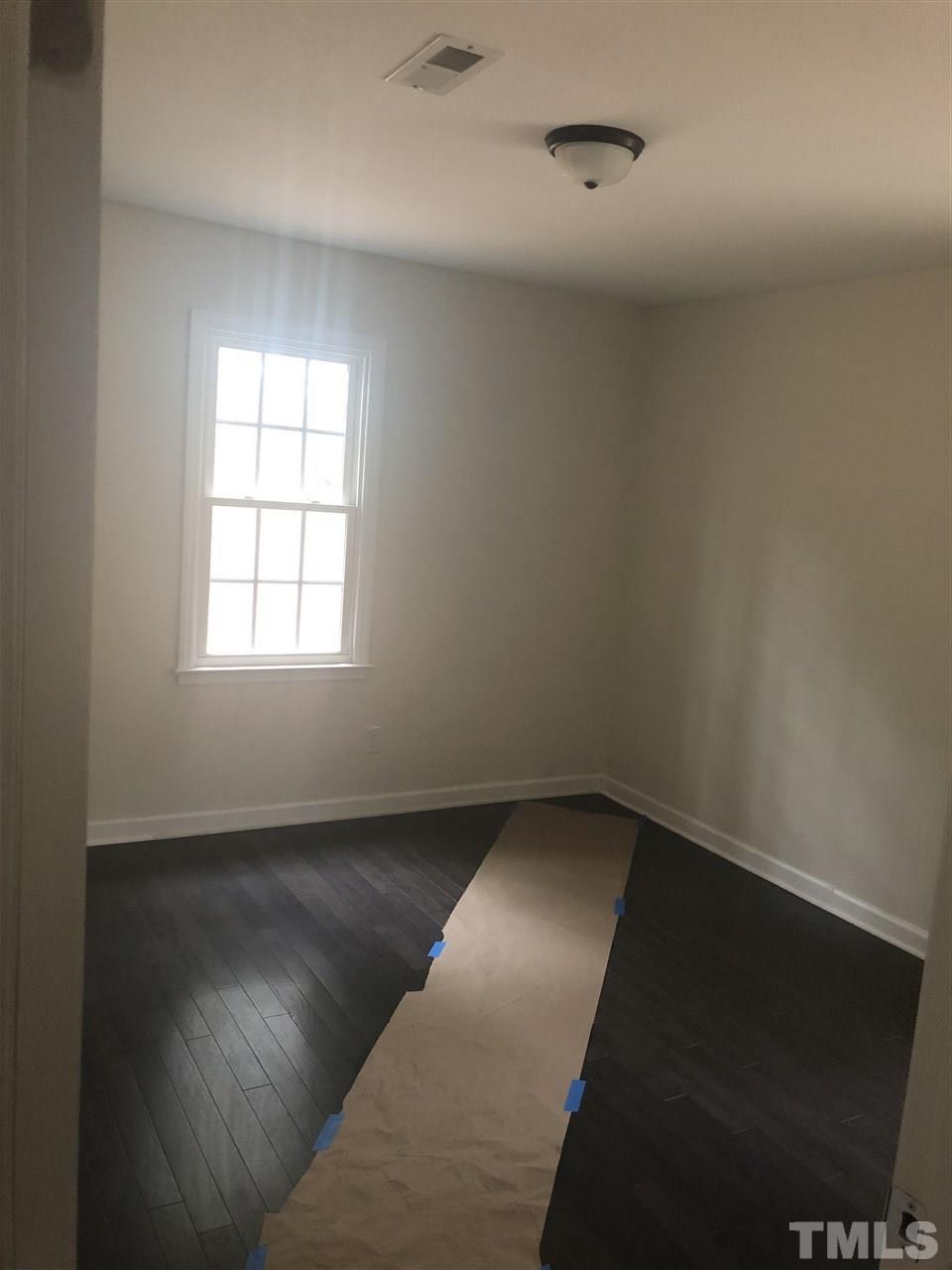 2900 Alron Road Wendell, NC 27591 - Photo 11 of 15 an empty room with wooden floor and windows