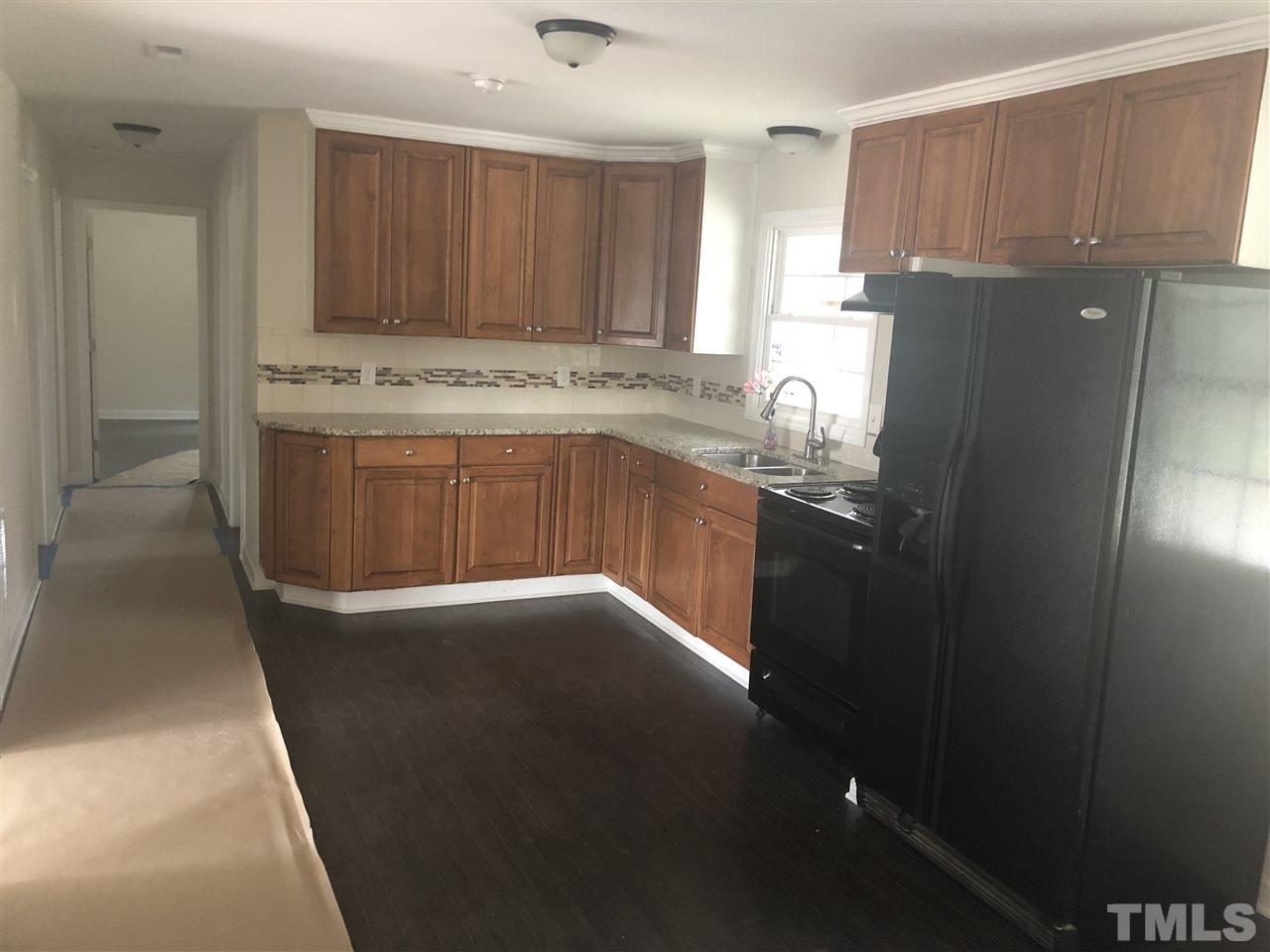 2900 Alron Road Wendell, NC 27591 - Photo 6 of 15 a kitchen with stainless steel appliances granite countertop a refrigerator a stove and a sink with wooden cabinets