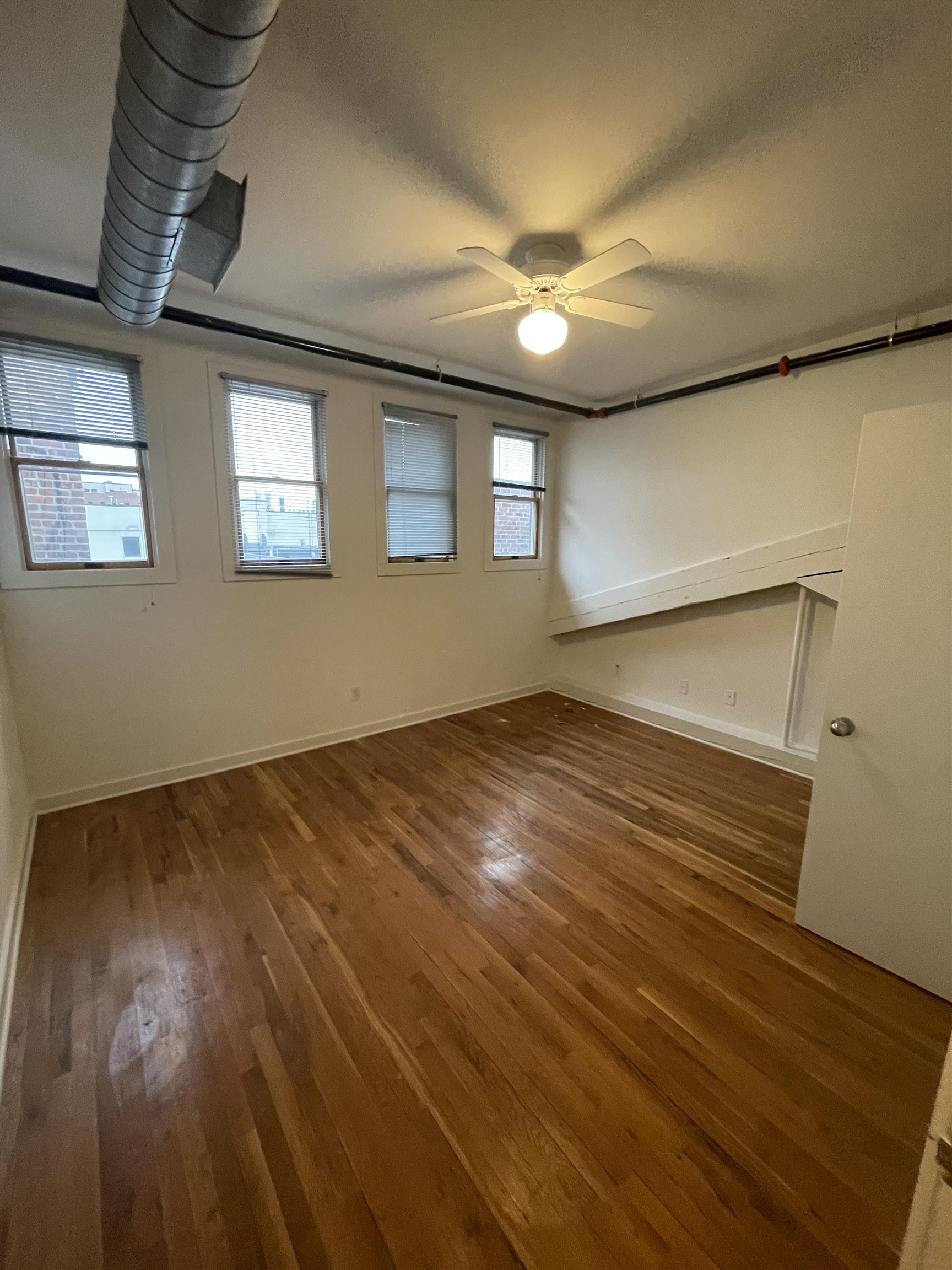 1017 Jefferson Street, Unit 321 Hoboken, NJ 07030 - Photo 8 of 10 a view of an empty room with wooden floor and a window