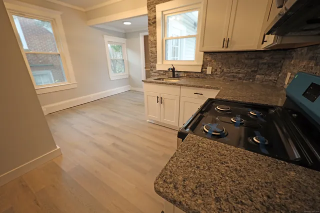 a kitchen with a sink a stove and cabinets