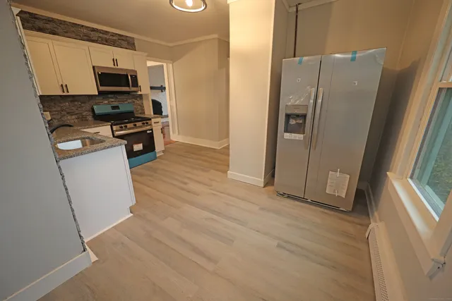 a kitchen with stainless steel appliances a refrigerator and a stove top oven