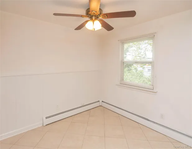 an empty room with a window and a fan